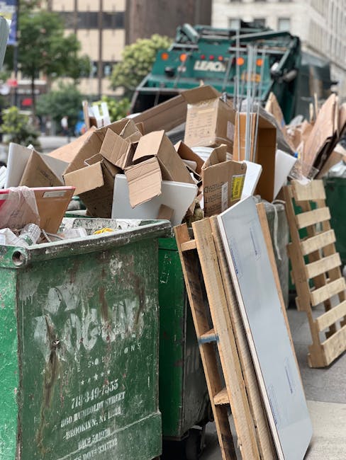 A collection of overflowing rubbish bins and scattered waste on a paved urban street, adjacent to a parking area with a small silver car parked nearby. The waste includes black, black with black and w